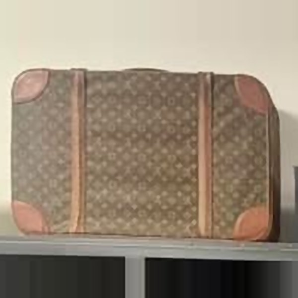 Louis Vuitton monogram canvas suitcase with leather corner trim, on the shelf at Silk & Stone