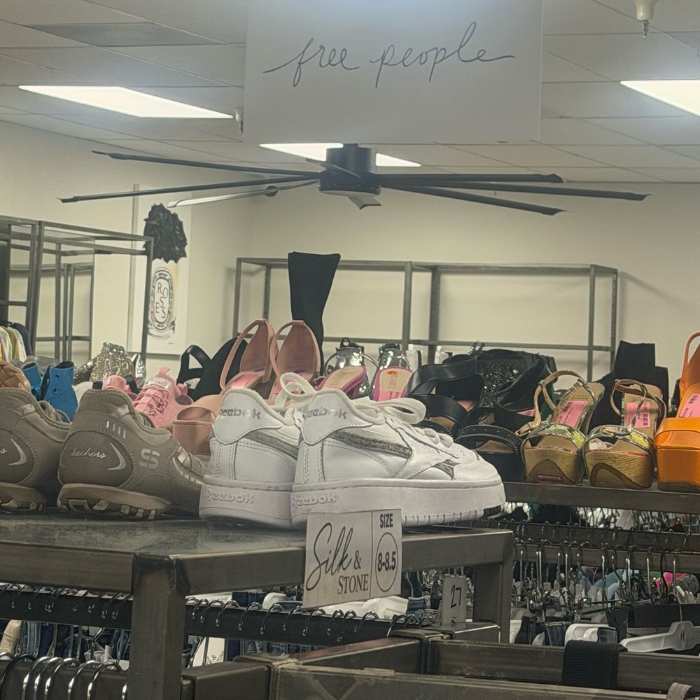 Shoes on the shelf at Silk & Stone, including white Reebok sneakers and heels, beneath a Free People sign